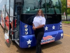Woman standing in front of blue tour bus